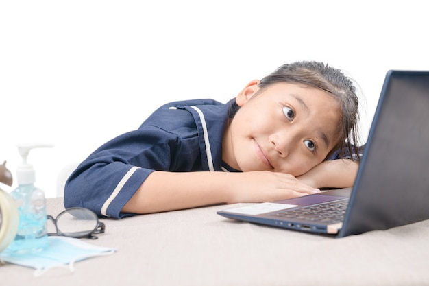 Glückliches süßes Mädchen, das Videos sieht, die online auf ihrem Laptop zu Hause streamen, isoliert auf Weiß. Homeschooling, Fernunterricht und neues normales Konzept