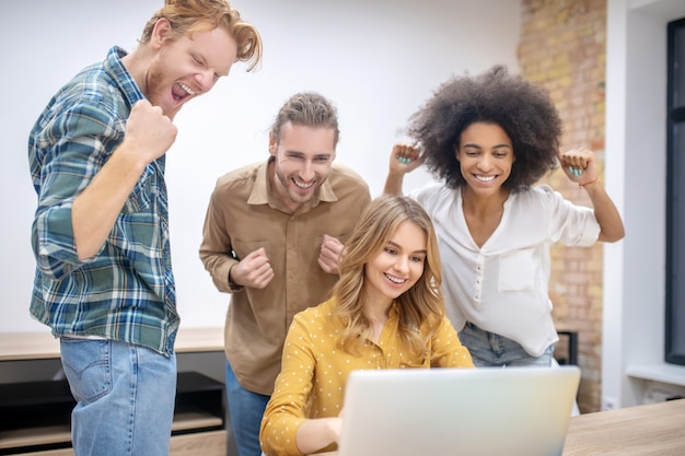 Glückliches Team. Junge Berufstätige, die zusammen im Büro arbeiten und glücklich aussehen