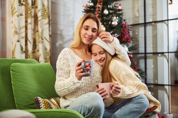 Glückliches Teenager-Mädchen, das sich zu Weihnachten mit Mama entspannt