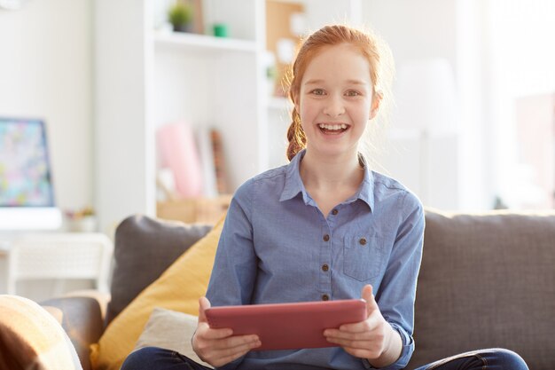 Glückliches Teenager-Mädchen, das Tablette hält