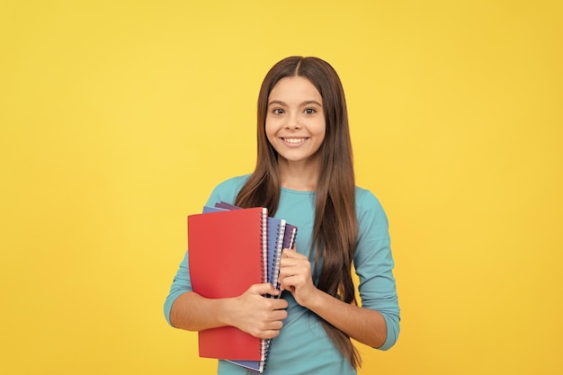 Glückliches Teenager-Mädchen mit Schulnotizbuch zum Anfertigen von Notizen