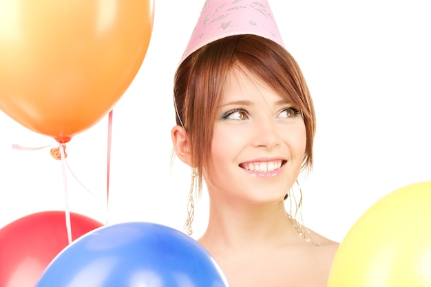 glückliches Teenager-Partygirl mit Luftballons über weißer Wand