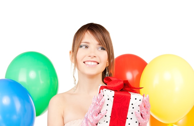 glückliches Teenager-Partymädchen mit Luftballons und Geschenkbox