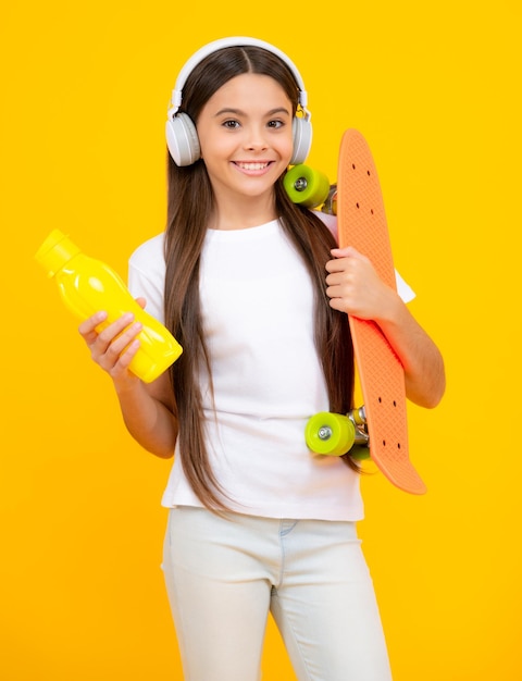 Glückliches Teenager-Porträt Studioaufnahme eines trendigen Teenager-Modemodells im lässigen Look Teenager-Jugend-Hipster-urbaner Lebensstil Kindermädchen im Streetstyle in Hipster-Kleidung mit einem Skateboard