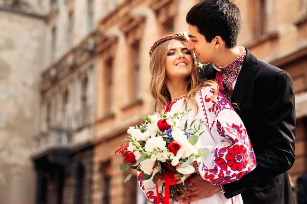 Glückliches ukrainisches Paar, das traditionelle Kleidung trägt