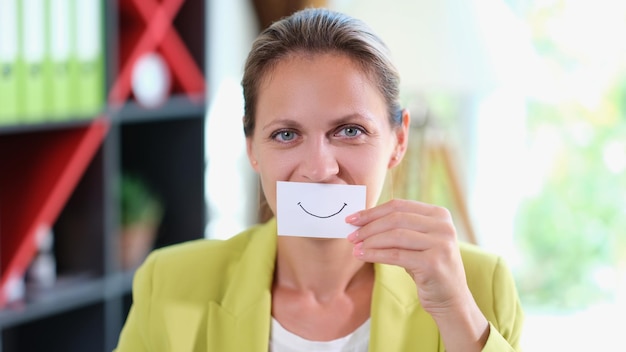 Glückliches und lächelndes Mädchen mit einem auf Papier gezeichneten Lächeln