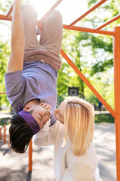 Glückliches und unbeschwertes Teenager-Paar, das Spaß auf dem Spielplatz in einem Stadtpark hat?