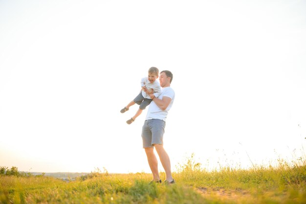 Glückliches Vater-Sohn-Kind, das gemeinsam im Park im Freien spielt. Familienvatertag, Elternschaft, aktives Lifestyle-Konzept