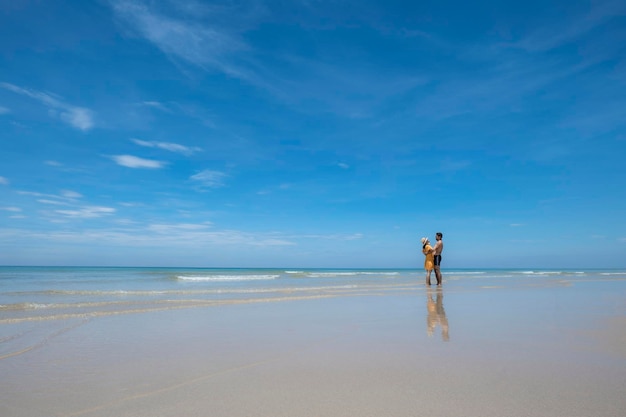 Foto glückliches verliebtes paar, das am strand bei sonnigem laufen spielt und in den wellen plantscht, reisen urlaubslebensstil