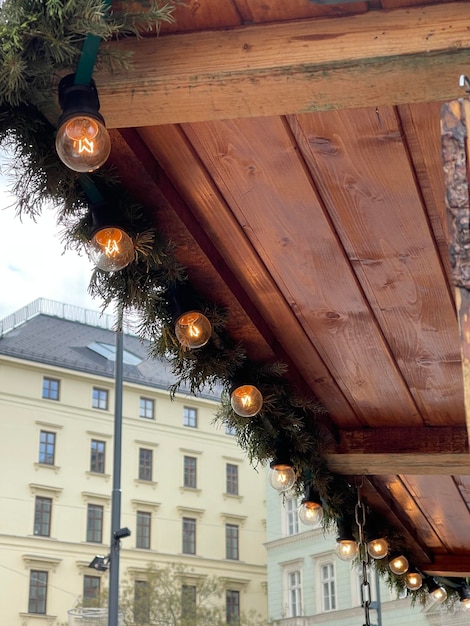 Glühbirnen im Edison-Stil auf Weihnachtsgirlanden auf einem Holzpavillon auf dem Weihnachtsmarkt in der Stadt