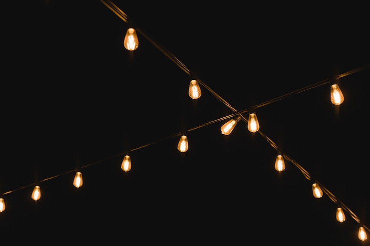 Foto glühbirnendekor in der party im freien. dekorative lichterketten im freien in der nacht. golden leuchtende girlande in der hochzeit