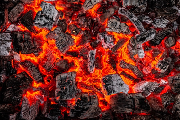 Glühende weiße und schwarze Kohle schwelt beim Grillen, bevor Fleisch gebraten wird