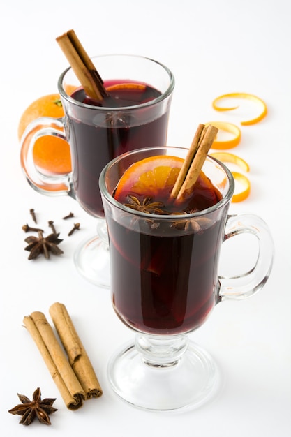 Glühwein im Glas mit dem Gewürz und Frucht getrennt auf Weiß