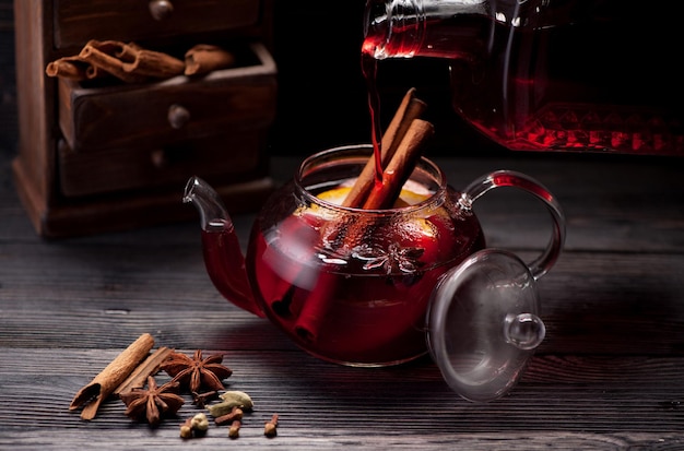 Glühwein mit Gewürzen auf Holzhintergrund