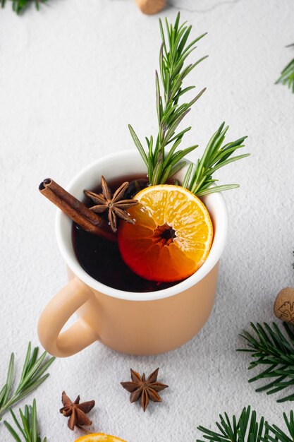 Glühwein mit Gewürzen mit Tannenzweigen und Mandarinen