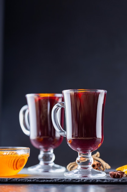 Glühwein mit Gewürzen und Orange in Glasbechern