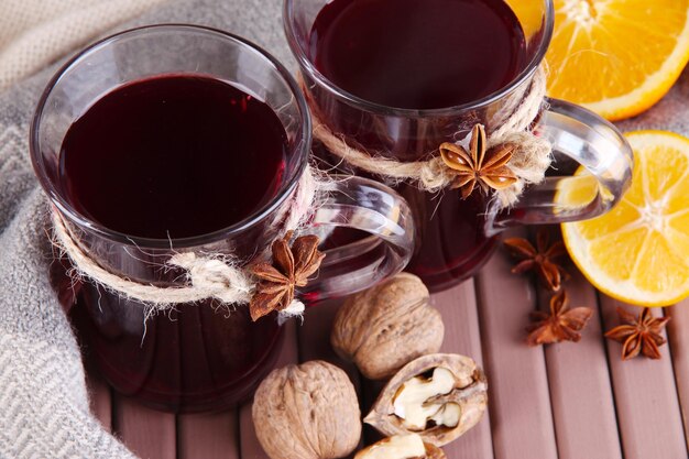 Glühwein mit Orangen und Nüssen auf dem Tisch aus nächster Nähe