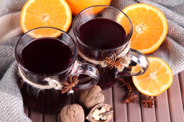 Glühwein mit Orangen und Nüssen auf dem Tisch aus nächster Nähe