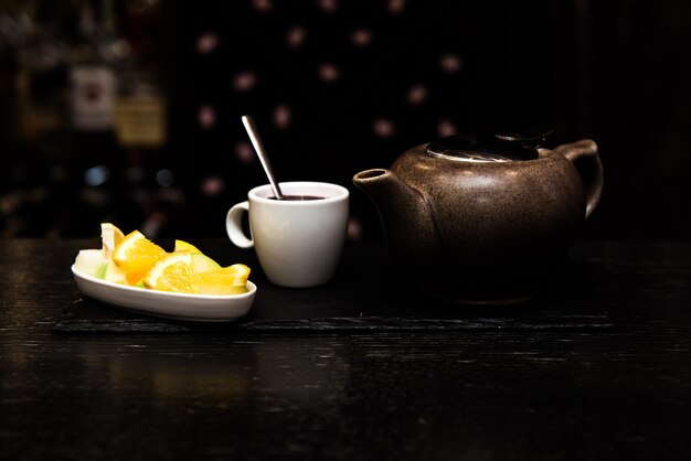 Glühwein Sangria Glühwein in einer weißen Tasse auf dunklem Hintergrund Bartheke mit Früchtetee und Gewürzen Zimtstangen und Orange