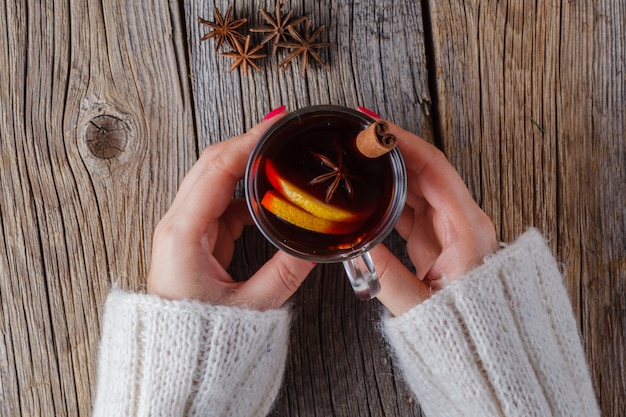 Glühwein und Gewürze auf verwittertem Holztisch