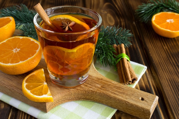 Glühwein und Mandarinen auf dem Holzschneidebrett