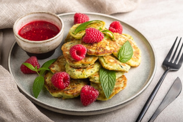 Foto glutenfreie zucchini-pfannkuchen mit himbeeren und himbeermarmelade. gesundes ernährungskonzept, sommeressen.