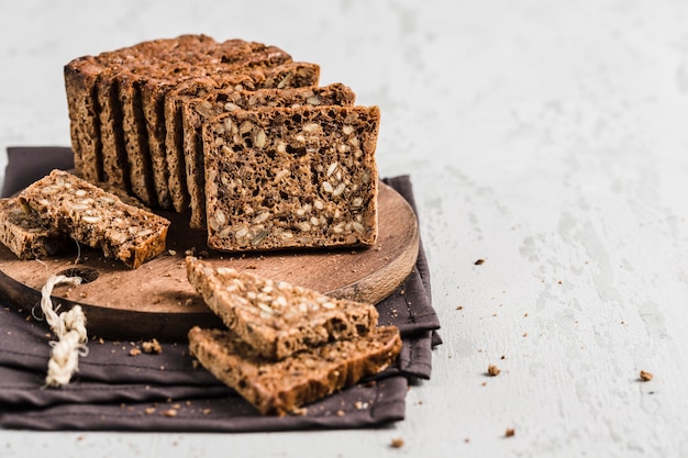 Glutenfreies Brot mit Haselnuss und Leinsamen auf einem hölzernen Brett