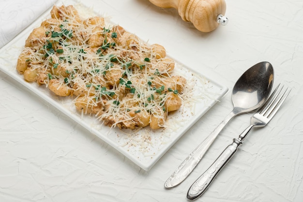 Gnocchi auf weißem Hintergrund mit Mehl