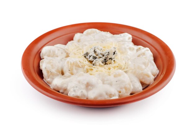 Los gnocchi cubiertos de queso azul y parmesán se sirven en un plato