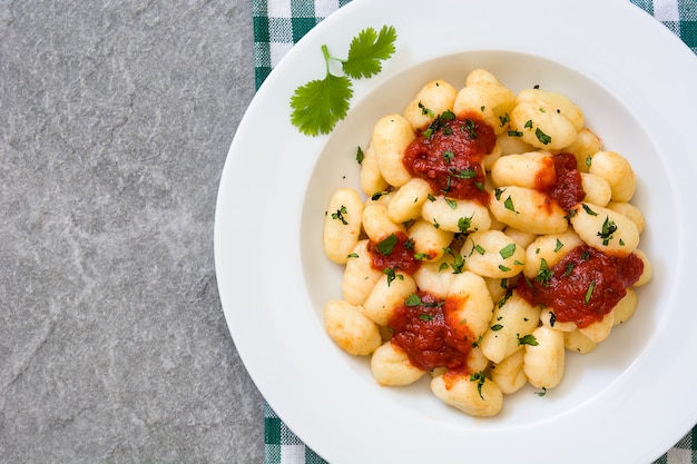 Gnocchi mit Tomatensauce auf grauem Stein