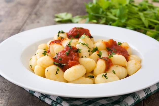 Gnocchi mit Tomatensauce auf hölzernem Hintergrund