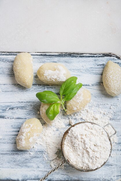 Gnocci de batata tradicional italiana decorada com folha de manjericão, ovos, farinha. vista do topo. postura plana