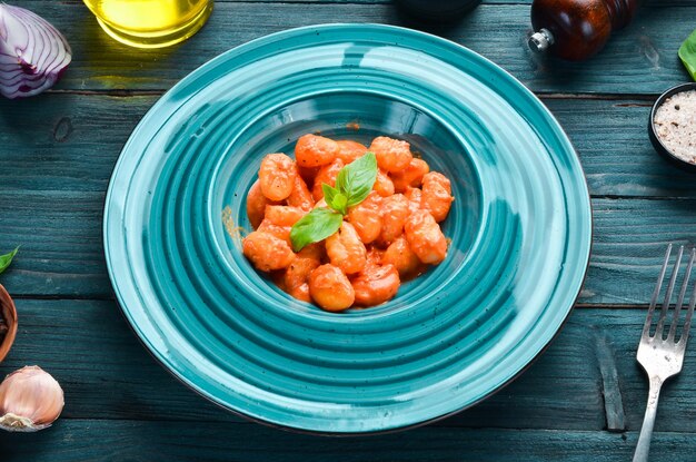 Gnocci mit Tomatensauce in der Platte Traditionelle italienische Küche Kartoffelknödel Draufsicht Freier Platz für Ihren Text Rustikaler Stil