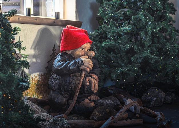 Gnomo de madeira com chapéus vermelhos e lenços perto da árvore de Natal