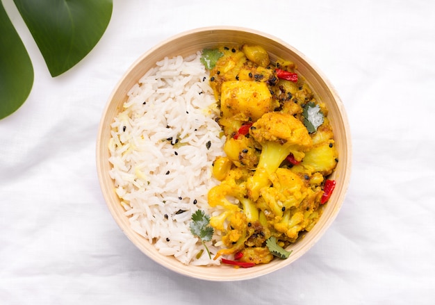 Gobi aloo prato vegetariano indiano de vegetais e batatas em uma tigela de bambu em um pano de linho branco
