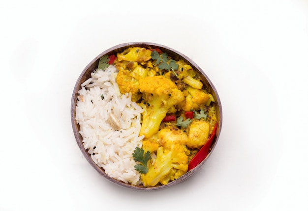 Gobi aloo traditionelles indisches vegetarisches Gericht des Blumenkohls in einem Teller mit Reis auf Weiß