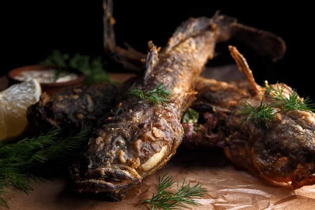 Gobio Gobiidae de pescado frito con salsa sobre una tabla de madera