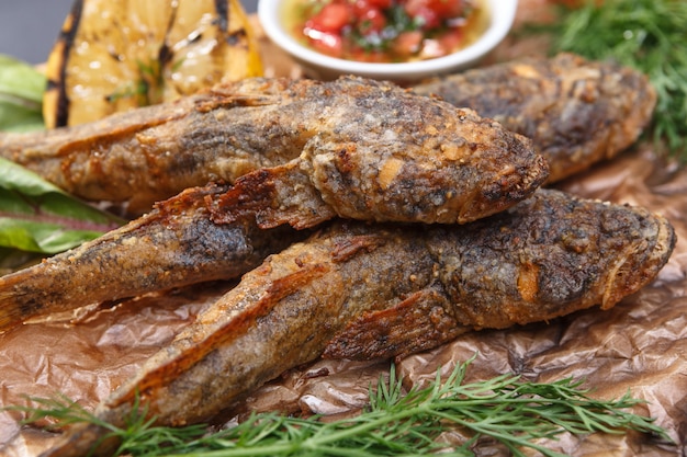 Goby de peixe frito com molho em uma placa de madeira