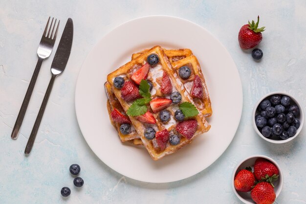 Gofres belgas con fresas, arándanos y sirope desayuno saludable casero