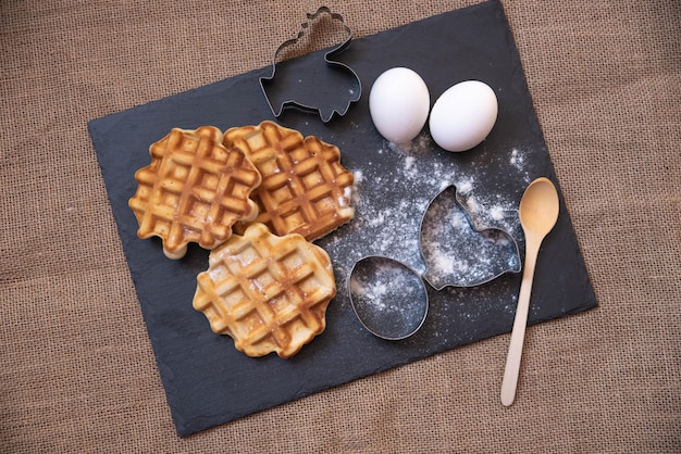 gofres calientes y huevos con moldes para un fondo negro