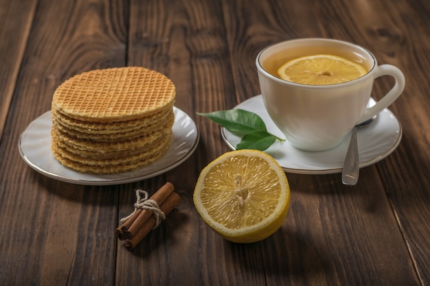 Gofres caseros y té con canela y limón sobre una mesa de madera. Tartas caseras con té.