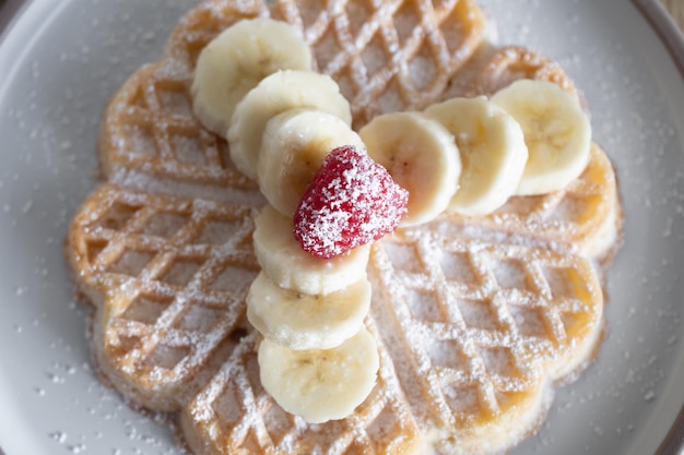 Gofres de postre con frambuesas y plátanos