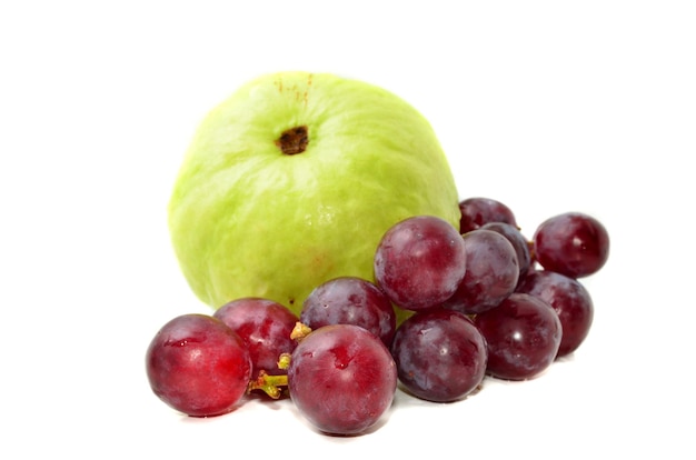 Goiaba fresca com uvas vermelhas isoladas no fundo branco