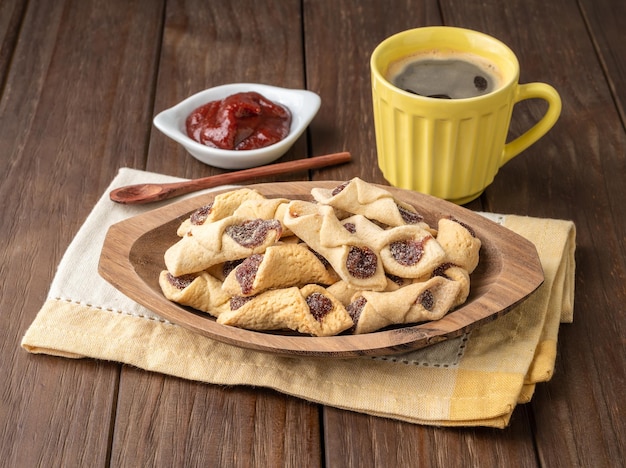 Goiabinha ou beliscao biscoito recheado de goiaba caseiro tradicional brasileiro com café sobre mesa de madeira