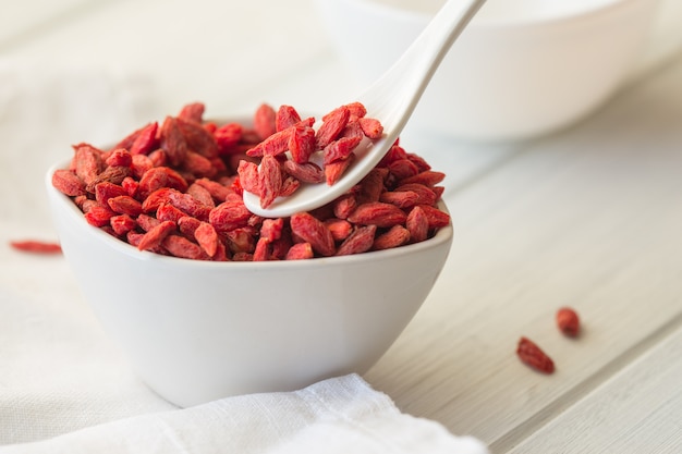 Goji in Schüssel auf Holztisch.