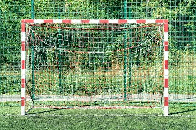 Gol em listras brancas e vermelhas para mini futebol em um campo de grama artificial