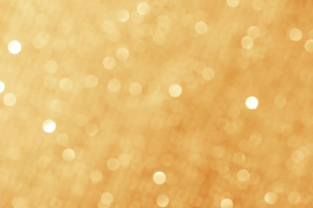 Gold glänzender Bokeh-abstrakter Unschärfehintergrund mit hellem rundem defocus goldenem Muster