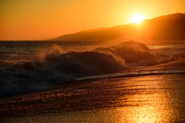 Gold Himmel und Meerwasser Meereswellen Hintergrund Sonnenuntergang am Meer Landschaft Dramatischer Sonnenuntergang Himmel mit Wolken Dramatischer Sonnenuntergang über dem Meer