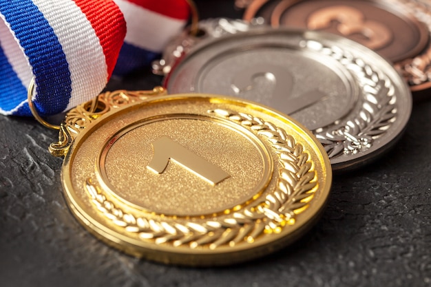 Gold-, Silber- und Bronzemedaille mit Bändern. Auszeichnung für den ersten, zweiten und dritten Platz im Wettbewerb. Preis für den Champion. Schwarzer Hintergrund.