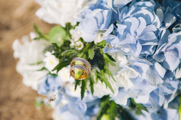 Gold Trauringe auf Bouquet mit schönen Hortensien